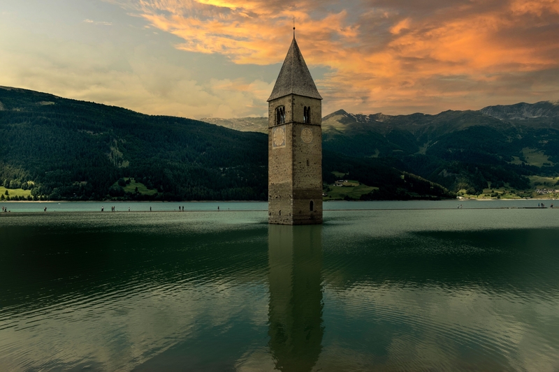 Ein teilweise überfluteter Glockenturm in Graun, Italien | Alamy Stock Photo by camilla66 