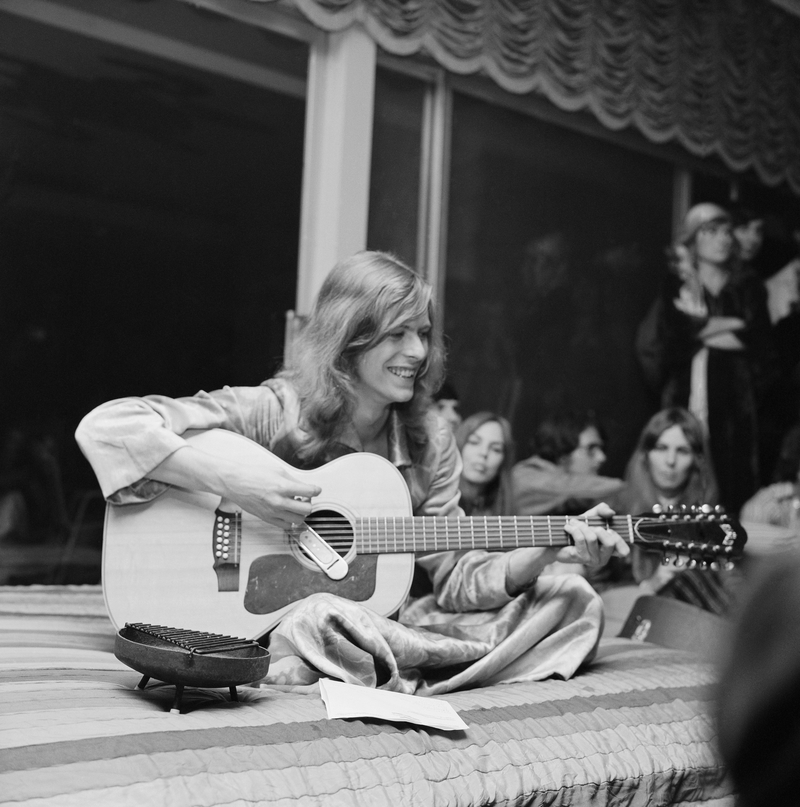Ein junger, Hippie-aussehender David Bowie tritt auf einer Party auf | Getty Images Photo by Earl Leaf/Michael Ochs Archives