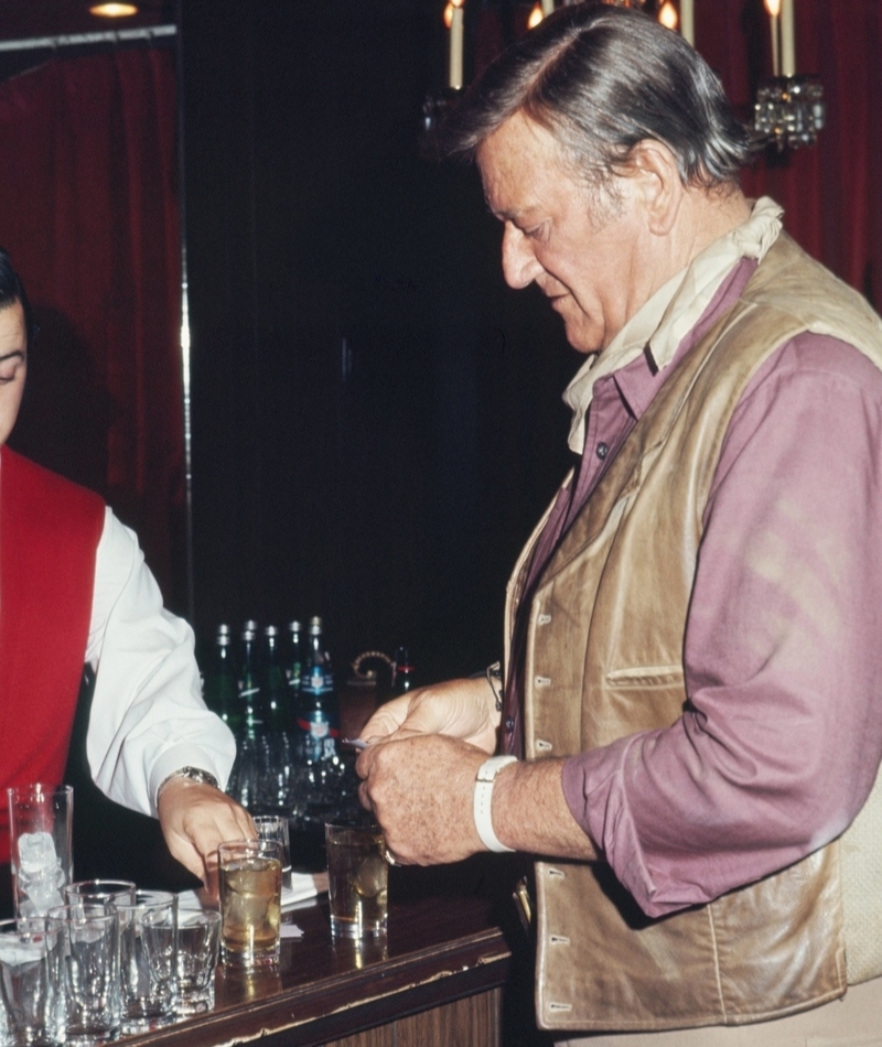 John Wayne bekommt auf einer Kostümparty Getränke | Getty Images Photo by Michael Ochs Archives